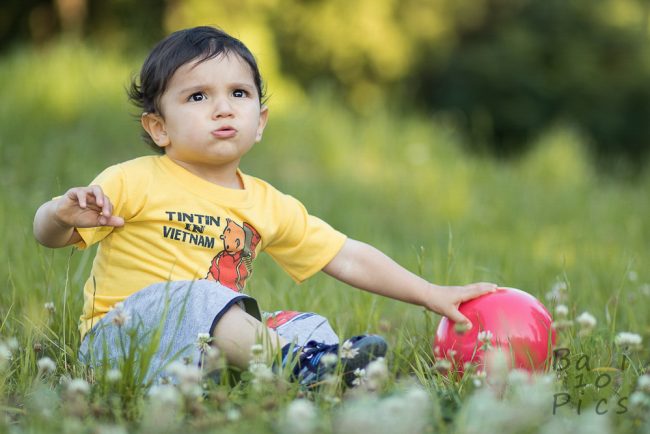 Kid with red ball in the forest