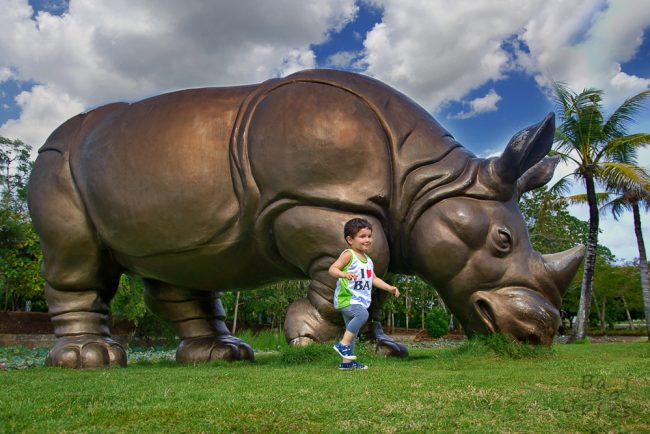 Kid with rhinoceros in GWK Cultural Park - Bali